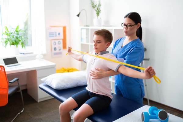 Image of a boy getting a sports physical by a chiropractor
