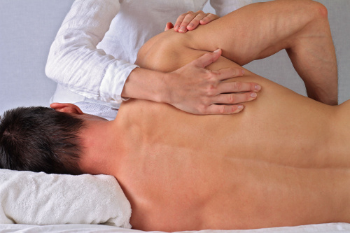 Photo of a chiropractor performing a spinal adjustment for a patient.