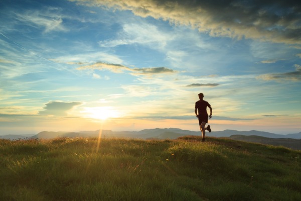 A person runs in nature at sunset