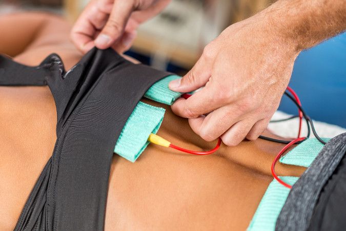 Electrical stimulation nodes placed on a back for herniated disc treatment.