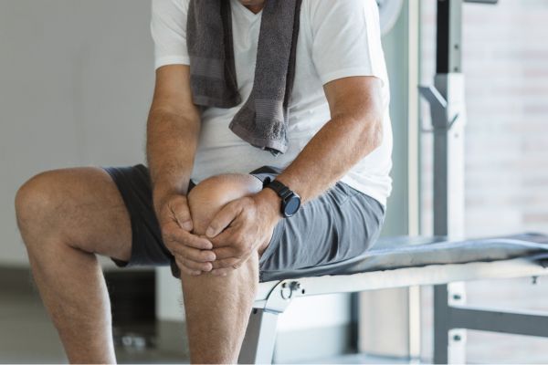 Man holds his knee after working out
