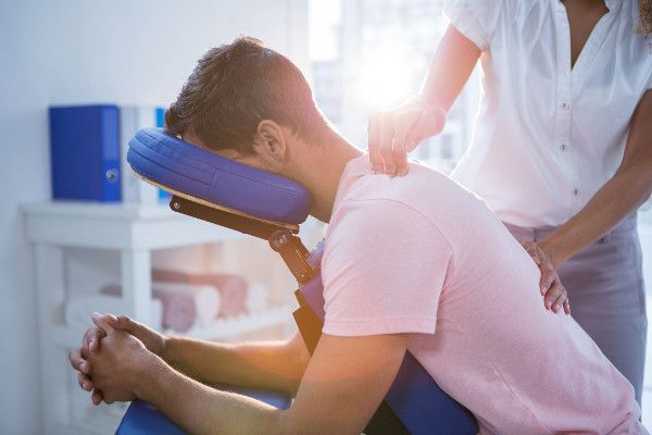 A chiropractor performs cervical spinal treatments on a patient