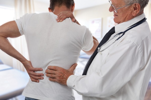 An image of a chiropractor treating a patient with back and neck pain from whiplash. 