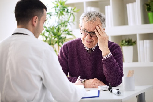 Image of Chiropractor talking with patient about their chronic pain.