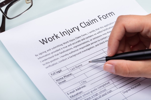 A person fills out a work injury claim form