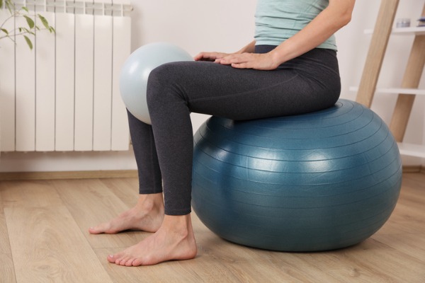 An image of a woman sitting on an exercise ball. 