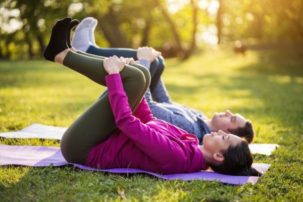 A pair performs healing exercises to loosen the back