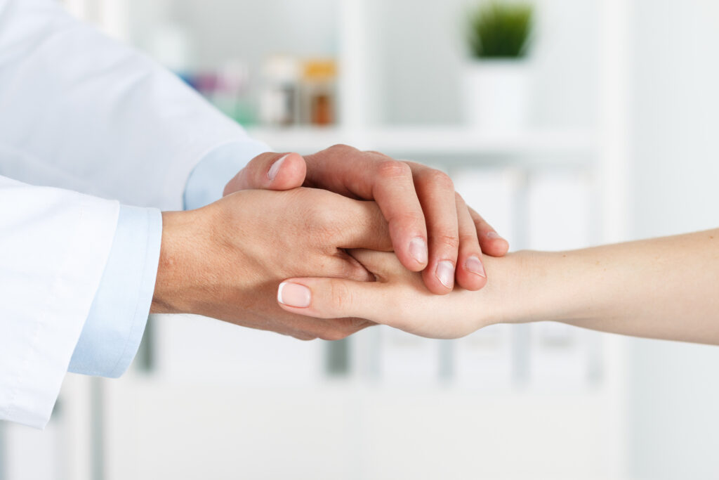 Doctor holding patients hand in comfort