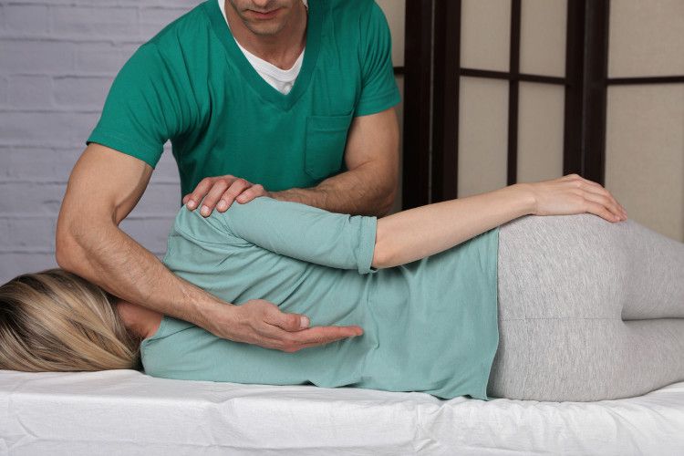 A woman receives a spinal adjustment from a chiropractor