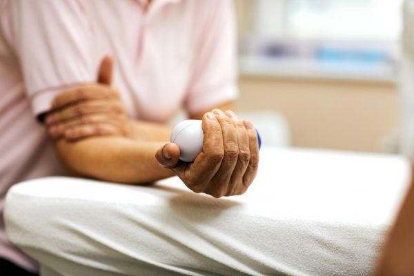 A person works on developing arm strength during physical therapy