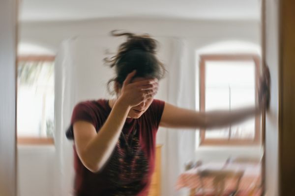 A woman holds her head in serious pain