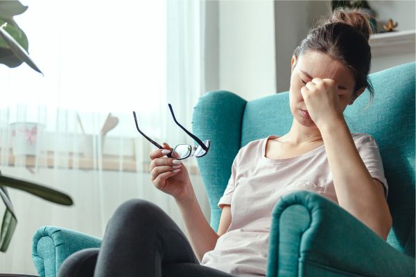 A woman having a headache holds her face in pain