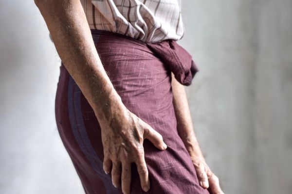 A woman holds her thigh because of sciatica nerve pain